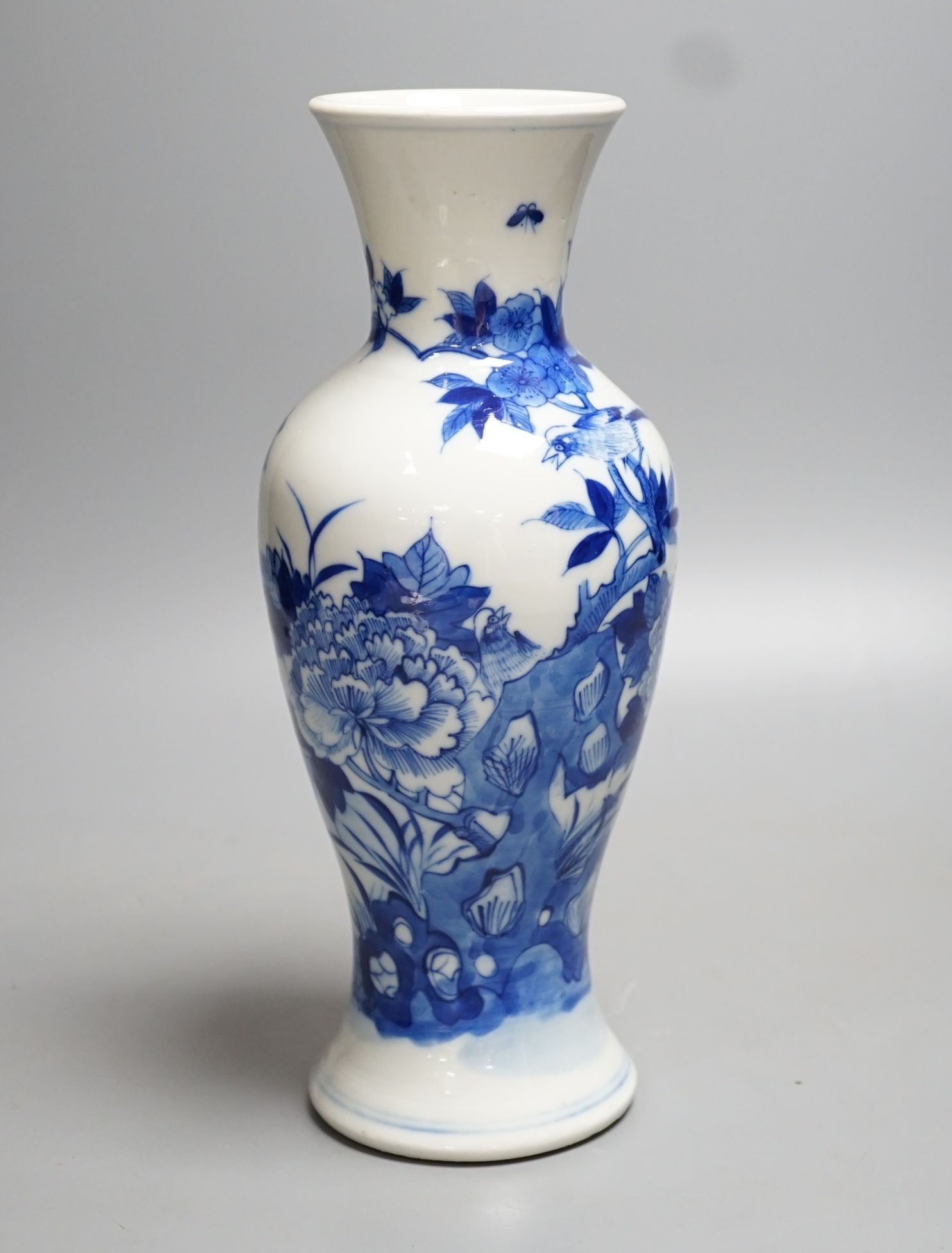 A late 19th century Chinese blue and white baluster vase, painted with birds amid flowers and rock work, pseudo Kangxi mark. 26cm